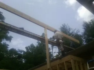 Carpenter setting a ridge beam over a new addition frame — Ice Dam Removal by Roofing Brothers in Sandgap