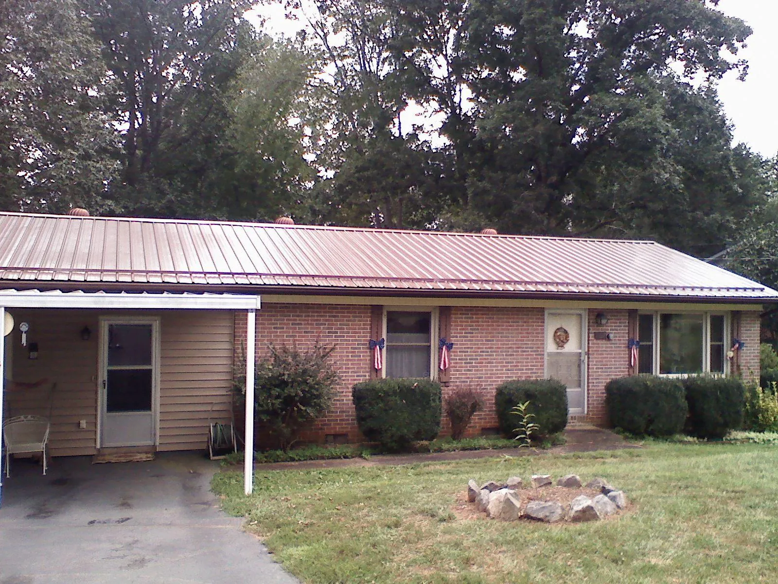 Bronze metal roof and carport on a brick ranch home — Roof Repair work by our crew in Sandgap